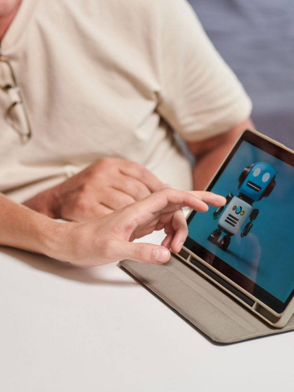 Son installing personal assistant on tablet computer of senior father